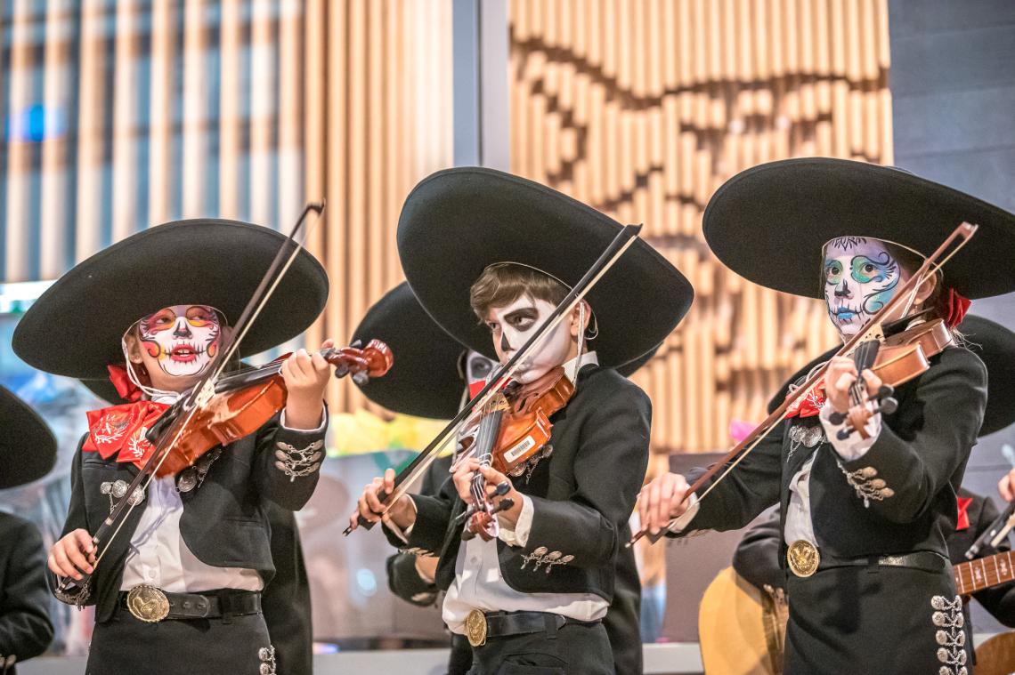 kids in mariachi outfits with painted faces playing violins